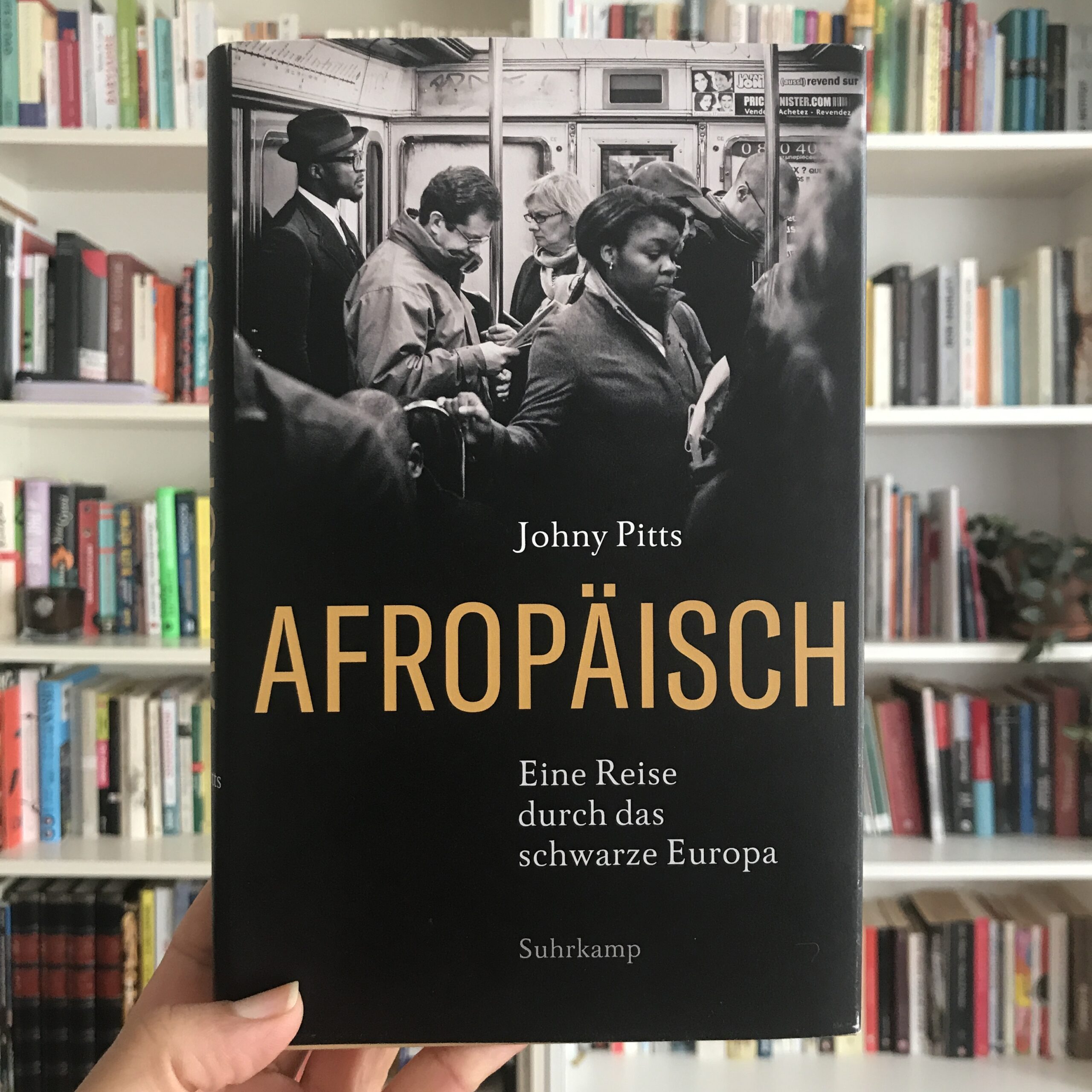 Das Buch Afropäisch von Johny Pitts vor Bücherregal